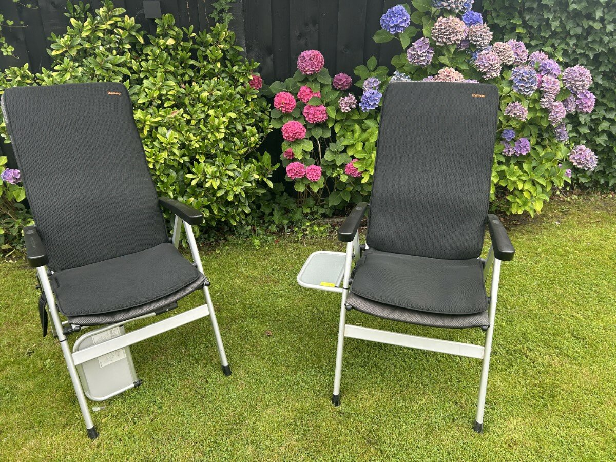 Twee kampeerstoelen met Thermrup verwarmde kussens in de tuin